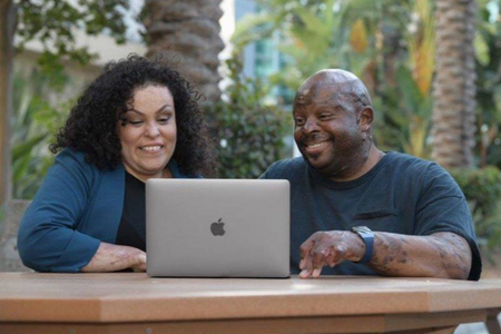 A group of two survivors looking at a computer. 