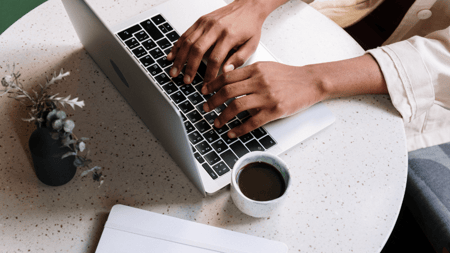 Women Typing on Mac with Coffee